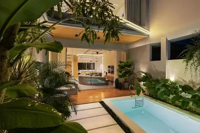 a house with a swimming pool with a lot of plants at New 2BR Architectural Masterpiece in Umalas in Kerobokan