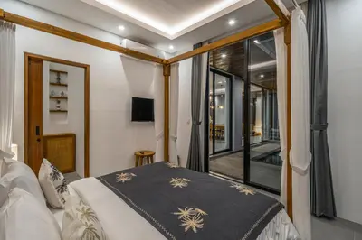 a bedroom with a bed and a large window at Bedawang, Exquisite Seminyak 4BR Villa with Huge Pool in Seminyak