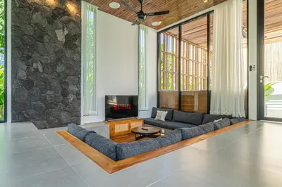 a living room with a couch and a fireplace at Bedawang, Exquisite Seminyak 4BR Villa with Huge Pool in Seminyak