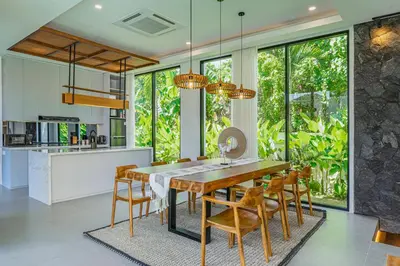 a kitchen and dining room with a wooden table and chairs at Bedawang, Exquisite Seminyak 4BR Villa with Huge Pool in Seminyak
