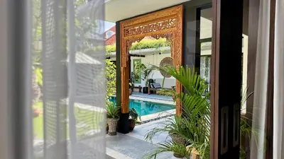 a door to a house with a pool and plants at Villa Mint Dua, Peaceful 3BR Villa - Near La favela Seminyak in Seminyak