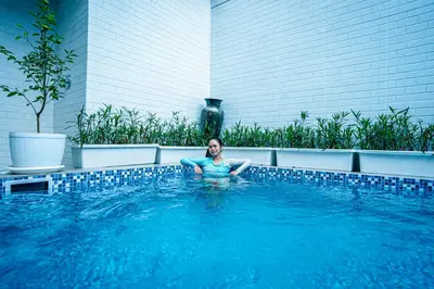 a woman is sitting in a swimming pool at Amshiga 4 in Jimbaran