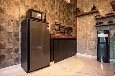 a refrigerator with a microwave on top of it in a kitchen at Amshiga 4 in Jimbaran