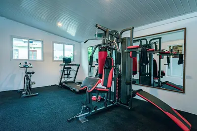 a gym with several tread machines and a mirror at Amshiga 4 in Jimbaran