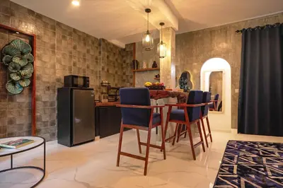 a kitchen with a table with chairs and a refrigerator at Amshiga 4 in Jimbaran
