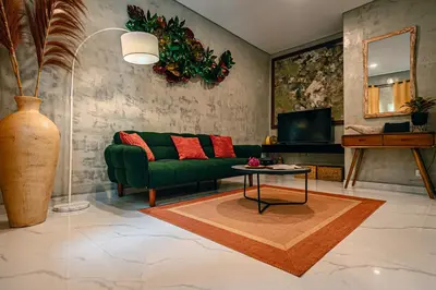a living room with a green couch and a table at Amshiga 5 in Jimbaran
