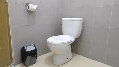a bathroom with a toilet and a trash can at Saphala Suites Secondfloor in Seminyak