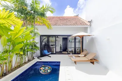 a villa with a swimming pool in front of a house at Villa Gael by Pertama Management in Seminyak