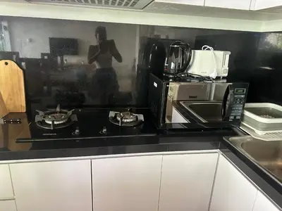a kitchen with a stove top and a microwave at Villa LAKSMI in Seminyak