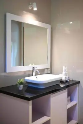 a bathroom with a sink and a large mirror at Villa LAKSMI in Seminyak