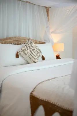 a white bed with two pillows and a lamp at Villa LAKSMI in Seminyak