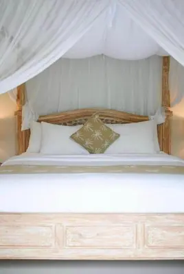 a bed with a canopy with two pillows on it at Villa Laskmi Legian in Seminyak