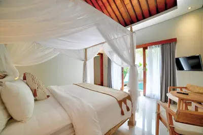 a bedroom with a white bed with a canopy at Villa Laskmi Legian in Seminyak