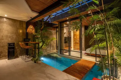 a swimming pool in the middle of a room with plants at Romantic Honeymoon Villa - Private Pool & Netflix in Dalung