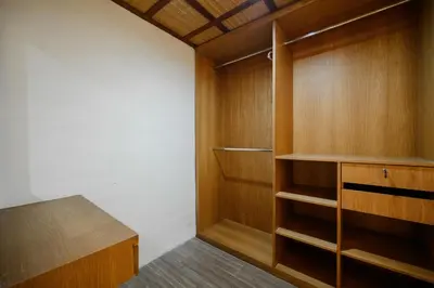 a closet with wooden cabinets and a wooden table at UrbanVilla in Legian