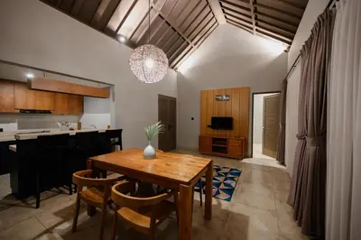 a kitchen and dining room with a wooden table and chairs at UrbanVilla in Legian