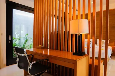 a desk with a lamp and a chair in a bedroom at Jineng Febe G Villa in Seminyak