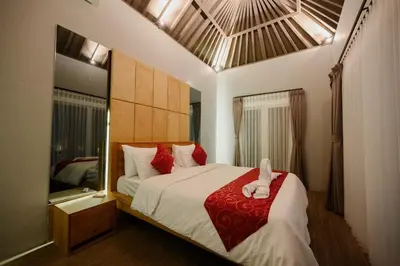 a bedroom with a large bed with a red blanket at Urban Villas 5BR in Legian