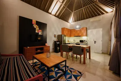 a living room with a table and a kitchen at Urban Villas 5BR in Legian