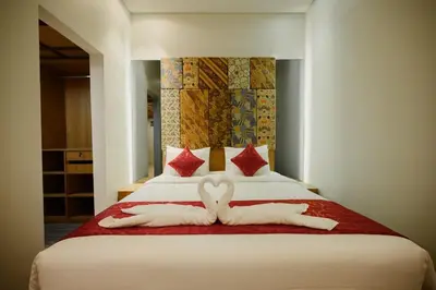 two towels in the shape of hearts are on a bed at Urban Villas 5BR in Legian