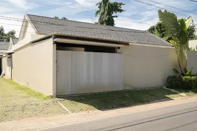 a white house with a garage at Cozy Villa Alami 2BR Sanur beachside in Sanur