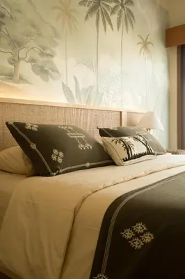 a bed with black and white pillows on it at Cozy Villa Alami 2BR Sanur beachside in Sanur