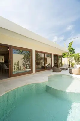 a house with a swimming pool in front of it at Cozy Villa Alami 2BR Sanur beachside in Sanur