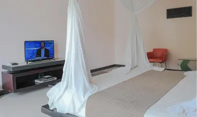 a hotel room with a bed and a television at Rishi Villas in Kerobokan