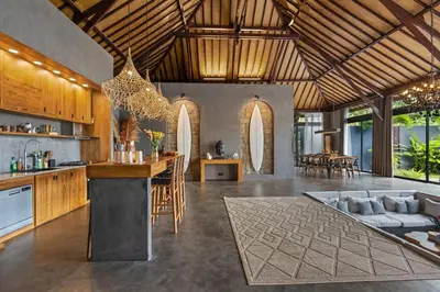 a kitchen and living room with a couch and a table at Exclusive 4BR Villa Kito - Cinema, Sauna, Yoga and Pool in Jimbaran