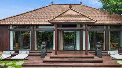 a gazebo with white chairs and a building at Exclusive 4BR Villa Kito - Cinema, Sauna, Yoga and Pool in Jimbaran