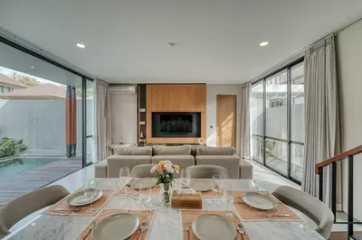 a dining room with a table with chairs and a television at Natadesa Villa 3BR Family Villa in Jimbaran in Jimbaran