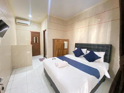 a bedroom with a large bed and a bathroom at SG Hotel - 2 Minutes to the Beach By Micky Studio 2 in Legian