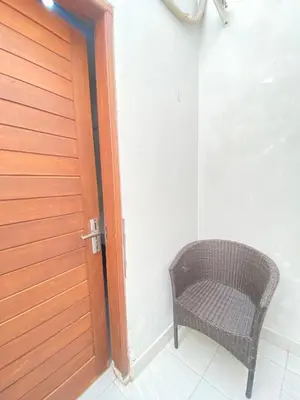 a wicker chair sitting next to a door at SG Hotel - 2 Minutes to the Beach By Micky Studio 2 in Legian