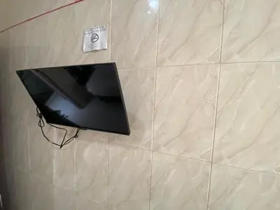 a flat screen tv on a tiled wall at SG Hotel - 2 Minutes to the Beach By Micky Studio 2 in Legian