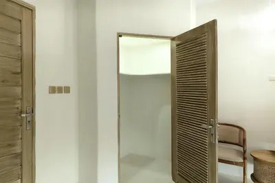 a glass door in a room with a mirror at Sandwood Bejiayu in Seminyak