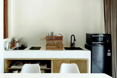 a kitchen with a counter with a sink and a microwave at Sandwood Bejiayu in Seminyak