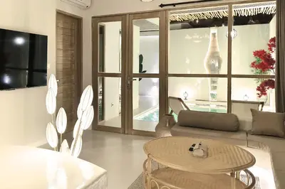 a living room with a table and a couch at Sandwood Bejiayu in Seminyak