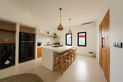 a kitchen with a counter and a island with bar stools at Villa Aura - Spacious 1BR Private Pool Luxury Villa in Seminyak