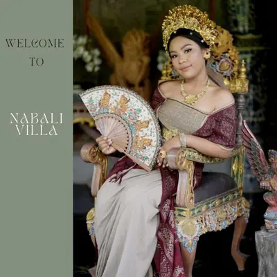 a woman sitting in a chair holding an umbrella at Nabali Villa in Kerobokan