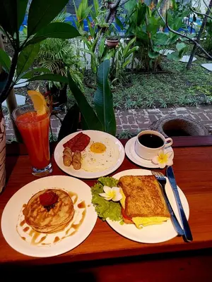 a table with plates of breakfast food and a cup of coffee at Nabali Villa in Kerobokan