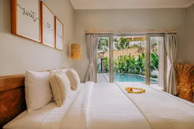 a bedroom with a large bed and a pool at Stylish 3BR Villa in Central Berawa Canggu - near Finns in Canggu