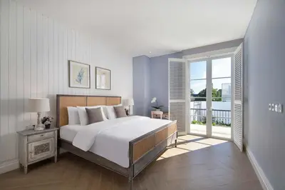 a bedroom with a large white bed and a balcony at Colonial House 4BR Villa Ocean View in Berawa in Canggu