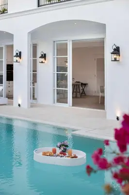 a house with a pool with a plate of food in it at Colonial House 4BR Villa Ocean View in Berawa in Canggu
