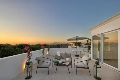 a patio with a table and chairs on a balcony at Colonial House 4BR Villa Ocean View in Berawa in Canggu