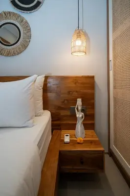 a bedroom with a bed with a wooden head board at Villa Bella Poppy in Seminyak