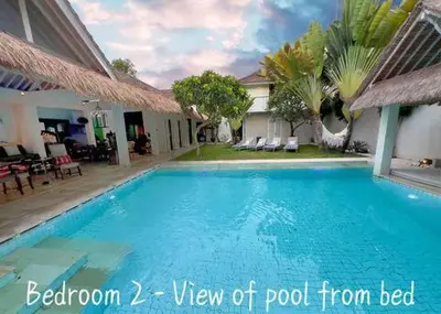 a large blue swimming pool in front of a house at Villa Anh Yeu - 6 BR in Central Seminyak with Huge Pool & Garden in Seminyak