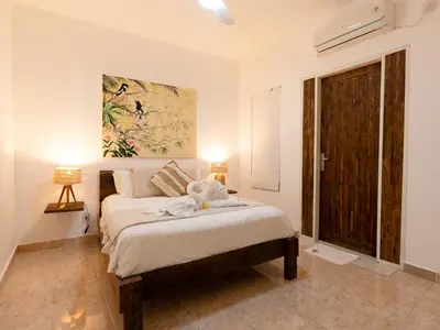 a bedroom with a bed and a large window at Whitehouse Villa 2 Bedroom Seminyak in Seminyak