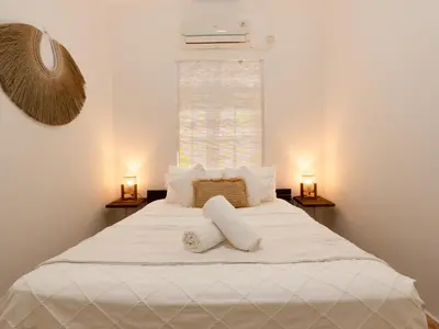 a bedroom with a white bed with towels on it at Whitehouse Villa 2 Bedroom Seminyak in Seminyak