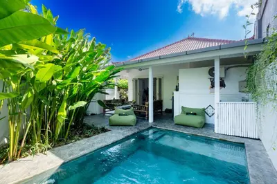 a villa with a swimming pool in front of a house at Whitehouse Villa 2 Bedroom Seminyak in Seminyak