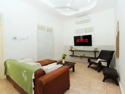 a living room with a couch and a tv at Whitehouse Villa 2 Bedroom Seminyak in Seminyak